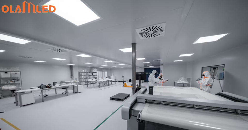 A cleanroom with several people working diligently on advanced machinery and equipment.
