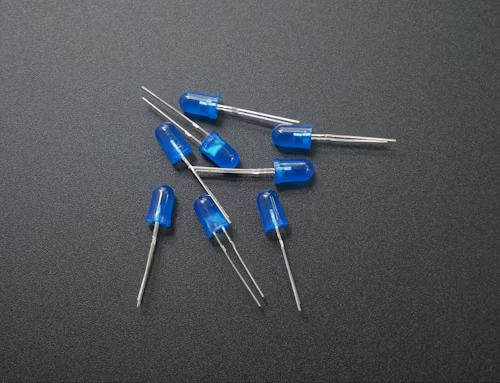 A group of glowing blue leds positioned on a black surface, highlighting their luminous quality in a dark setting.