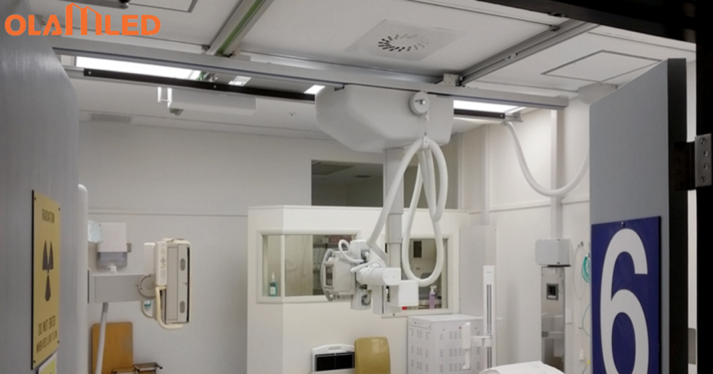 A hospital x ray radiation room featuring white walls, a white door, and led cleanroom troffer lighting.