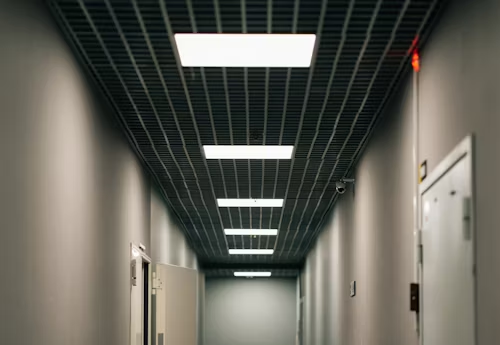 A long hallway illuminated by a ceiling panel light, creating a bright and inviting atmosphere.