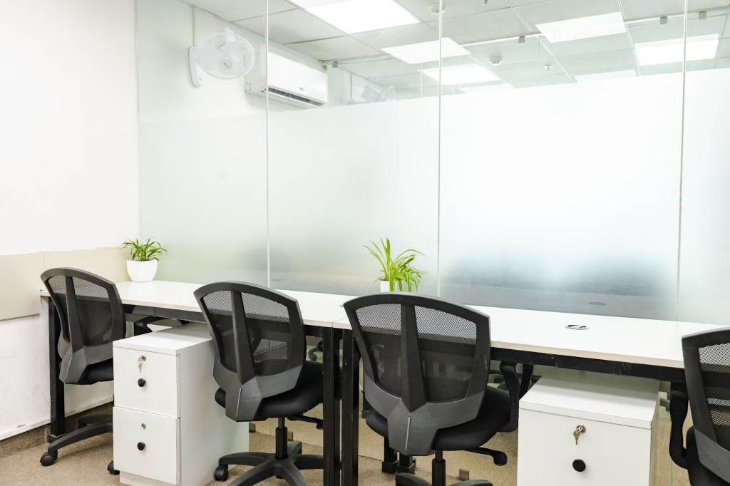 An office environment showcasing a desk and chairs by a window, with light provided by an led panel fixture.