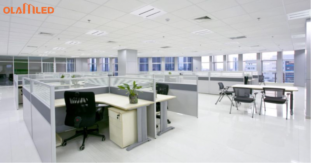 An office environment showcasing cubicles and desks under led lighting for a bright workspace.