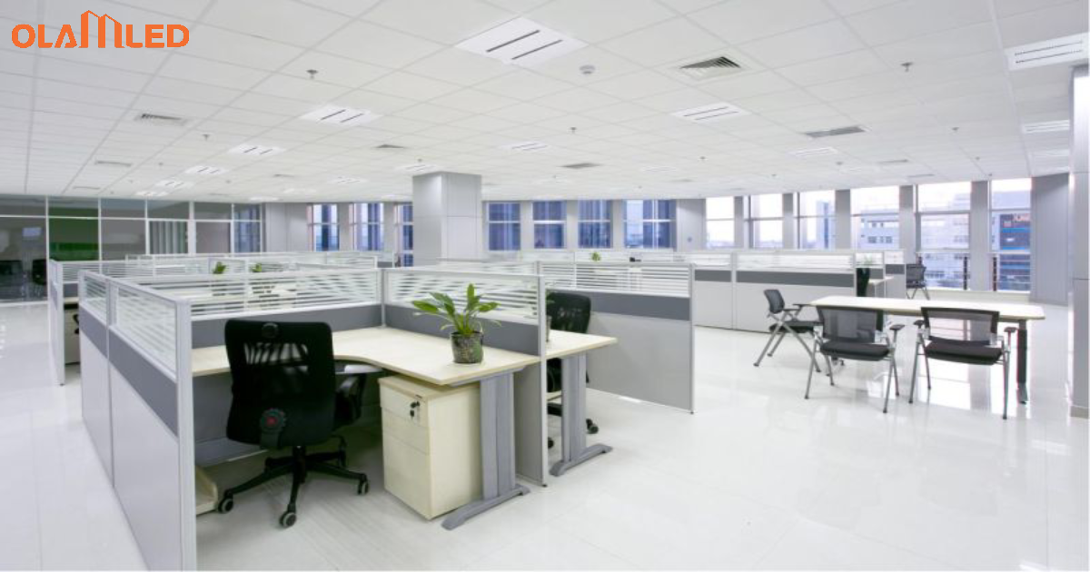 An office environment showcasing cubicles and desks under led lighting for a bright workspace.