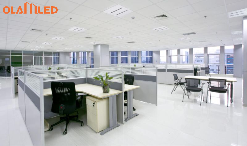 An office environment showcasing cubicles and desks under led lighting for a bright workspace.