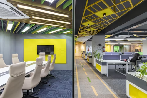 An office interior showcasing yellow and green accents, with led lights creating a cheerful and inviting ambiance.