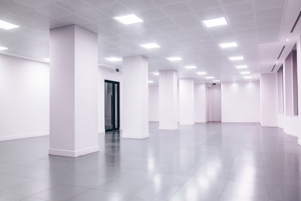 Empty white room featuring white columns and a white floor, illuminated by soft led lighting.
