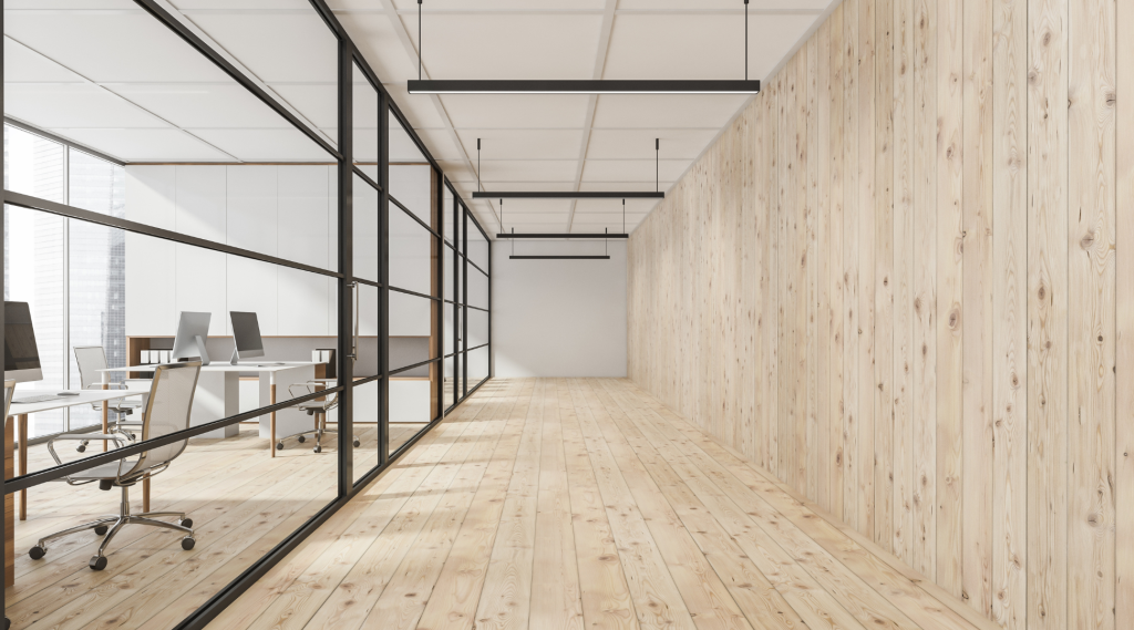 Modern open office with glass partitions, wooden wall panels, and suspended led linear lights