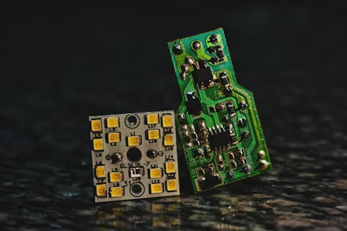Two small led components resting on a black surface, showcasing their intricate design and electronic features.