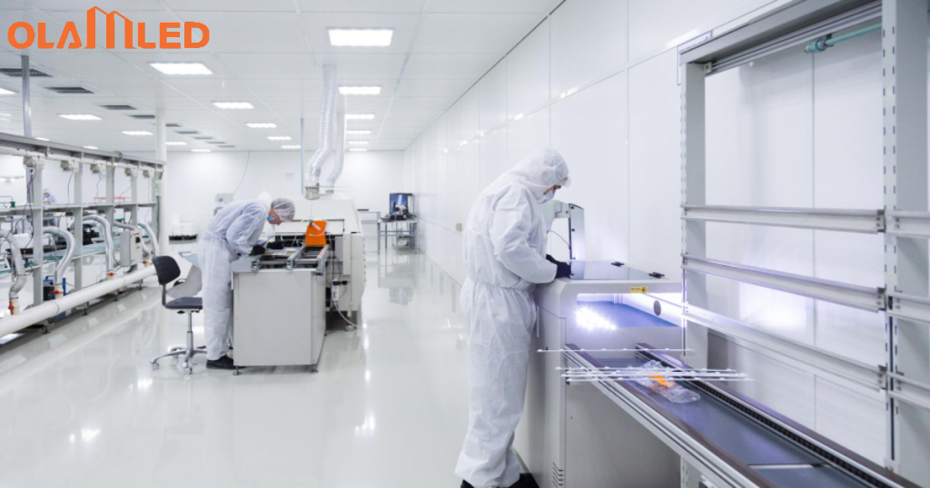 Two workers in white suits conducting tasks in a cleanroom environment, ensuring contamination free conditions.